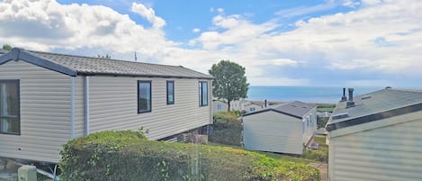 A row of mobile homes with a clear view of the sea in the background.