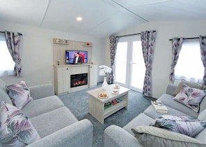 A living room with a fireplace, a television, and patterned curtains. - 3 bedroom accommodation in Ettrick Valley, Nr Hawick (Ettrick Valley, Nr Hawick)