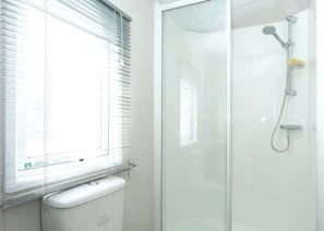 A bathroom with a glass shower enclosure, a toilet, and a window with blinds. - 3 bedroom accommodation in Ettrick Valley, Nr Hawick (Ettrick Valley, Nr Hawick)