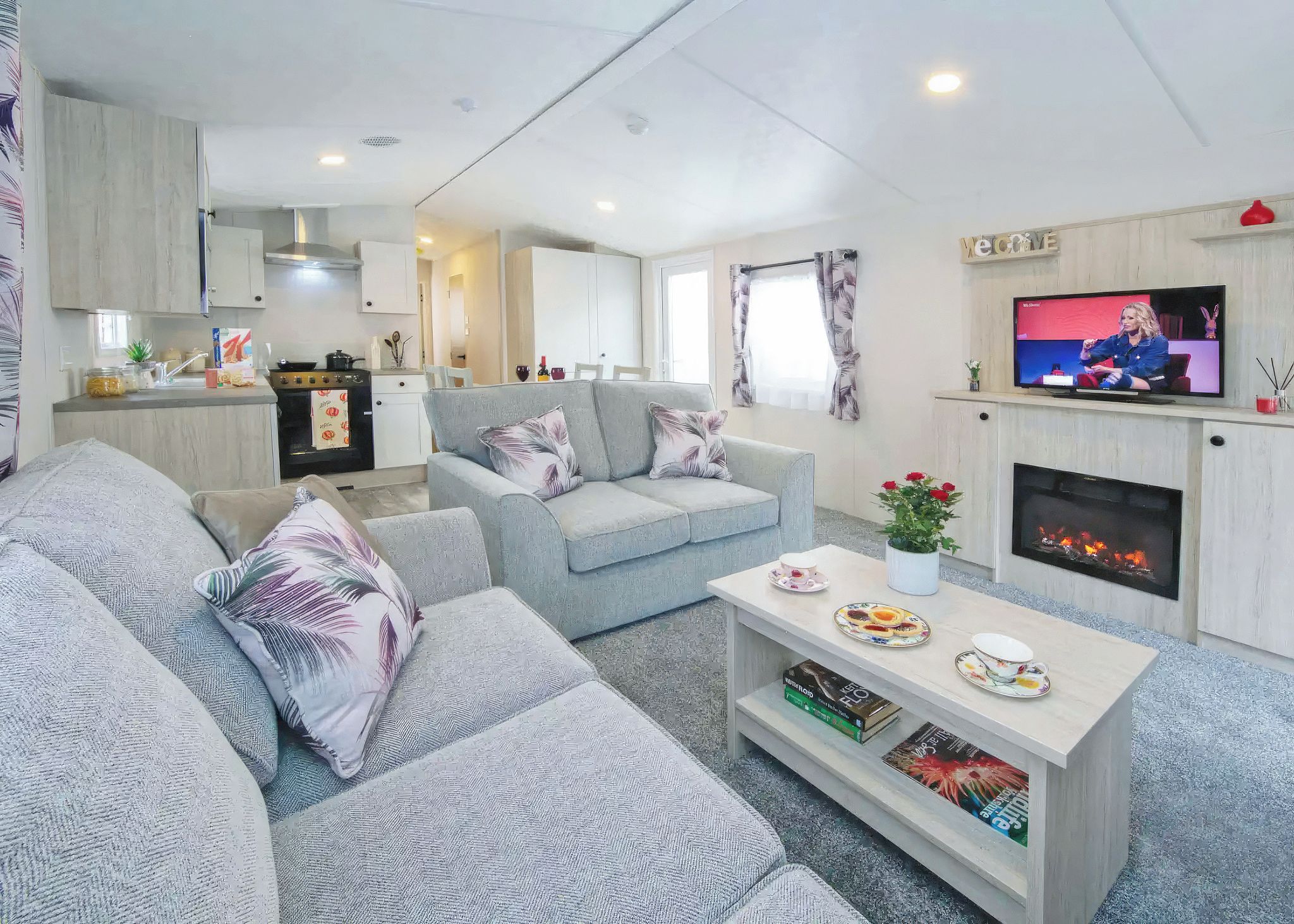 A modern living room with a sofa set, a coffee table, and a television.