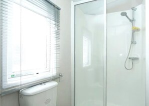 A bathroom with a glass shower enclosure, a toilet, and a window with blinds. - 1 bedroom accommodation in Ettrick Valley, Nr Hawick (Ettrick Valley, Nr Hawick)
