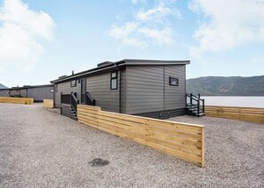 A modern building with a flat roof, a staircase, and a wooden deck. - 1 bedroom accommodation in Invermoriston (Invermoriston)