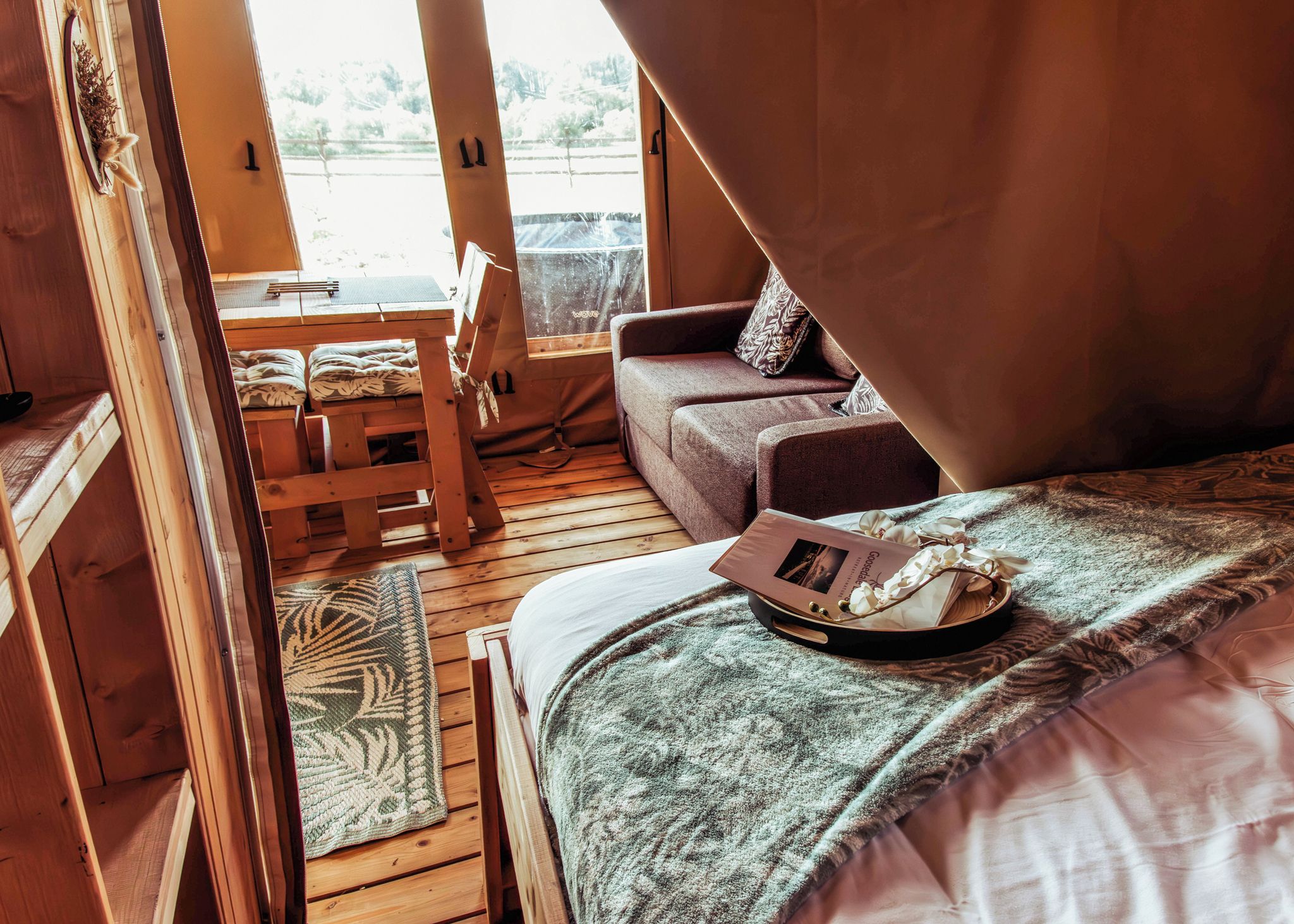 A cozy interior with a bed, a sofa, and a dining area.