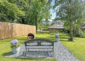 A garden with a metal bench, a barbecue grill, and a wooden fence. - Glamping Pod with hot tub - Pet Friendly (Bassenthwaite, near Keswick)