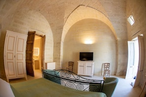 A room with a bed, a television, and a white cabinet. - Masseria Lilei (Lizzanello)