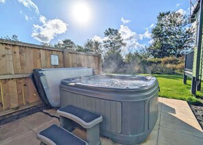 A hot tub with steps and a wooden fence in the background. - Tweed Spa + - 2 Bedroom (Pet Friendly) (Coldstream)