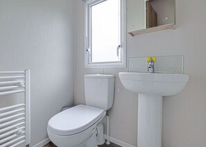 A bathroom with a toilet, a sink, and a window. - Tweed Spa + - 2 Bedroom (Pet Friendly) (Coldstream)