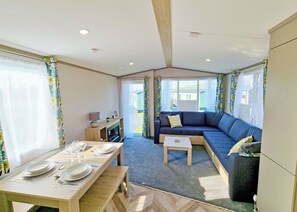 A compact living space with a dining area, a sofa, and a small table. - Tweed Spa + - 3 Bedroom (Pet Friendly) (Coldstream)