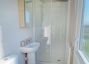 A modern bathroom with a glass shower enclosure, a white sink, and a toilet. - Tweed Spa + - 3 Bedroom (Pet Friendly) (Coldstream)