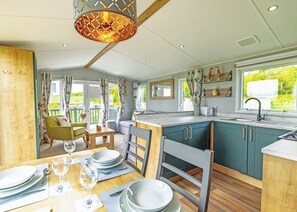 Eine moderne Küche mit Essbereich, Holzboden und Blick auf Grünflächen.