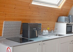 A compact kitchen with a Vitini coffee machine, a microwave, and a toaster on a countertop. - Aura Spa + Glamping Pod (Pet Friendly) (Coldstream)