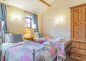 A bedroom with two beds, a wooden wardrobe, and a window with curtains. - 1 bedroom accommodation in Beverley (Beverley)