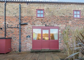 A brick building with a red door and two windows. - 1 bedroom accommodation in Beverley (Beverley)