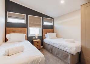Ein Hotelzimmer mit zwei Betten, einem Nachttisch und einem Kleiderschrank.