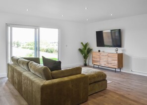 A modern living room with a sofa, a flat-screen TV, and a plant. - 1 bedroom accommodation in Hatfield (Hatfield)