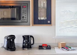 A kitchen with a microwave, coffee maker, and a box of Yorkshire tea. - Signature Plus2 bedroom lodge hot tub pet friendly (Anstruther)