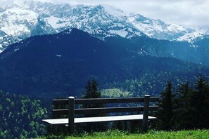 Eine Bank in einer grünen Wiese mit Bergblick.