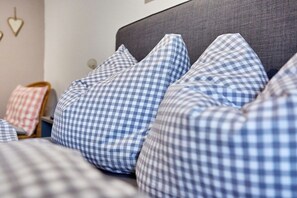 A bed with blue and white checkered pillows. - Holiday apartment Graseck (Garmisch-Partenkirchen)