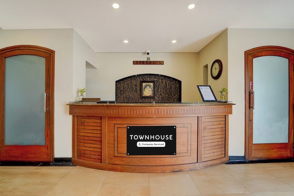 A reception desk with a sign indicating 'RECEPTION' and 'TOWNHOUSE' with a 'Company-Serviced' label.