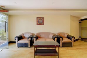 Una sala de estar con un conjunto de sofá, una mesa de centro y un adorno de pared.