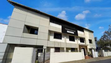 Un immeuble moderne avec une enseigne indiquant qu’il s’agit d’une maison de ville gérée par une entreprise de gestion immobilière.
