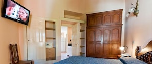 A bedroom with a bed, a wardrobe, a television, and a desk. - Las Cuatro Estaciones (Carilo)