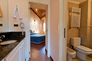 Une salle de bain équipée de toilettes, d’un bidet et d’un porte-serviettes.