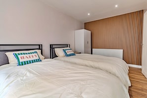 A bedroom with two beds, a wardrobe, and a radiator. - Finest Retreats | Charnwood Forest Lodge (Shepshed)