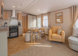 A compact living space with a kitchenette, dining area, and seating. - The Juniper Platinum is our signature caravan collection. (Dawlish)
