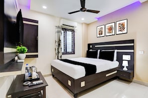 Een moderne slaapkamer met een bed, nachtkastje en een plafondventilator.