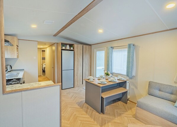 A compact living space with a kitchenette, a dining area, and a seating area. - 1 bedroom accommodation in Dawlish (Dawlish)