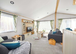 Ein modernes Wohnzimmer mit einer Couch, einem Fernseher und einem Couchtisch.