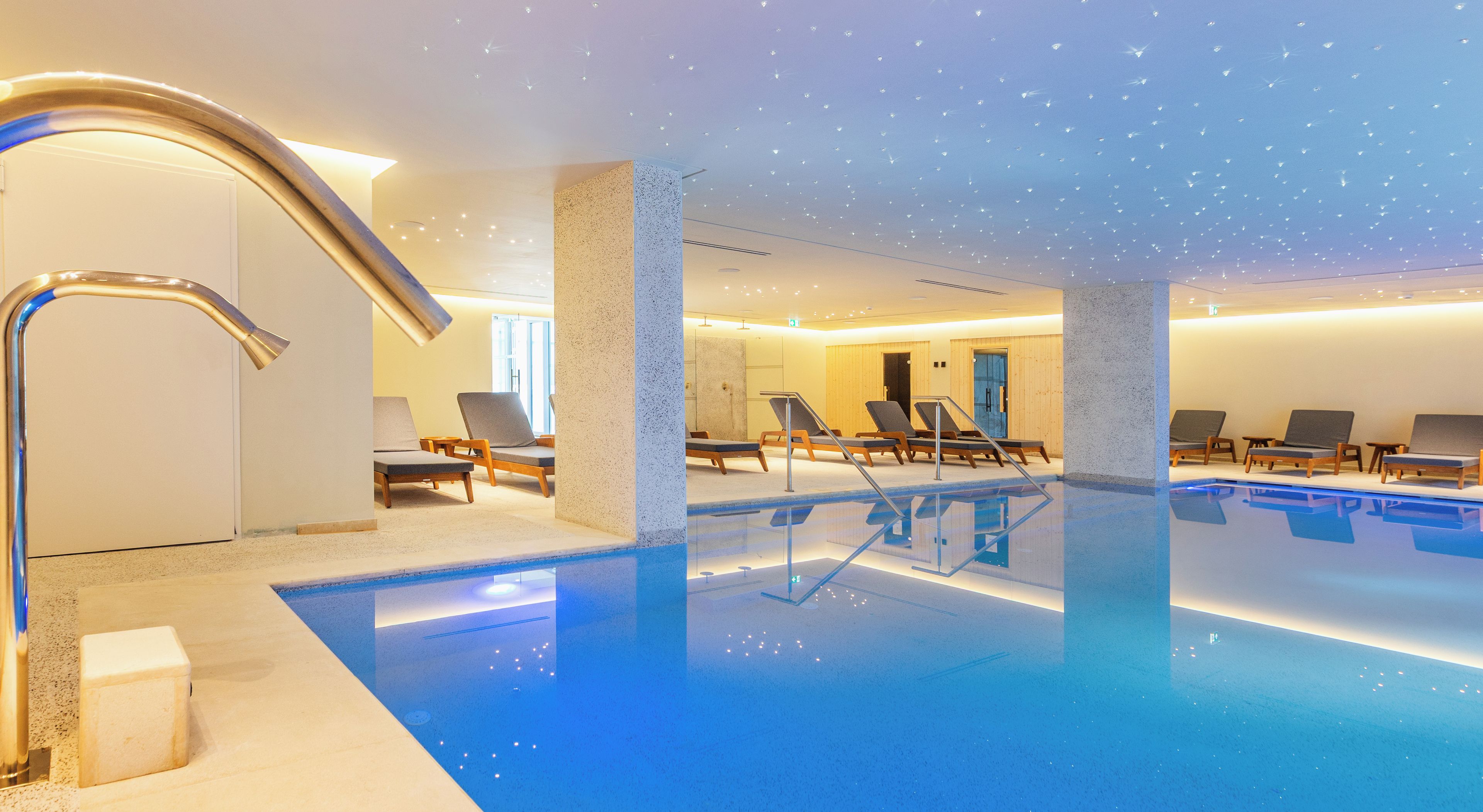 Zona de piscina con sillones de descanso y diseño moderno.
