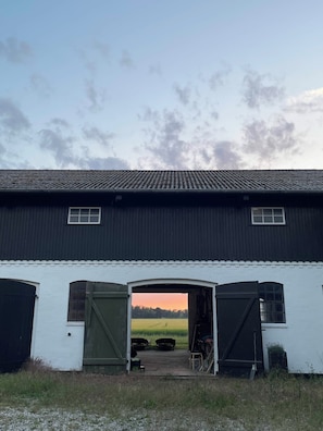 Eine Scheune mit zwei offenen Toren, die zu einem Feld führen.