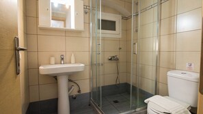 A bathroom with a glass-enclosed shower, a sink, and a toilet. - Alto Studio by CorfuEscapes (Kerkira)