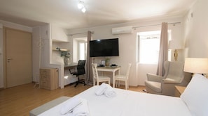 A hotel room with a bed, a desk with a chair, a TV, and a window with curtains. - Alto Studio by CorfuEscapes (Kerkira)