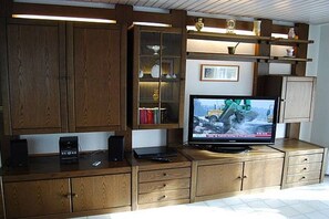 A wooden entertainment center with a television, speakers, and a laptop. - Rolf Bauer on the ground floor (Konstanz)