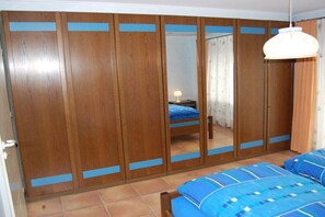 A bedroom with a bed, a wardrobe, and a mirror. - Rolf Bauer on the ground floor (Konstanz)