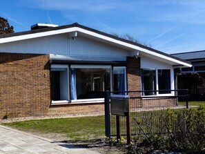 A modern building with a brick facade, large windows, and a metal fence. - Holiday Home With 4 Bedrooms (Julianadorp)