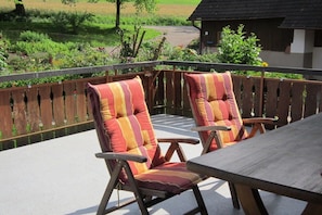 A wooden deck with two chairs and a table. - Holiday apartment with 1 bedroom (Seelbach)