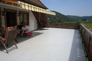A covered outdoor seating area with a view of a mountainous landscape. - Holiday apartment with 1 bedroom (Seelbach)