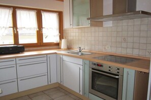 A kitchen with a built-in oven, a sink, and cabinets. - Holiday apartment with 1 bedroom (Seelbach)