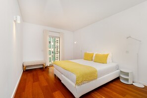 Une chambre à coucher avec un lit, une lampe de chevet et un banc.