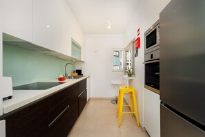 A modern kitchen with a stainless steel refrigerator, a microwave, and a sink. - Bright & Modern T1 near Tagus River (Algés)