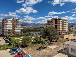 A residential area with multi-story buildings, a parking lot, and a small pool area. - Studio 'Estudio con terraza a 100 m de la playa en Torrox Costa' (Torrox)