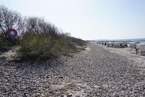 A gravel path leading to beach huts with a red sign on the left. - Holiday apartment 5 - Flounder (Börgerende)
