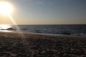 A beach with sand and water, and the sun is visible in the sky. - Holiday apartment with 2 bedrooms (Wismar)
