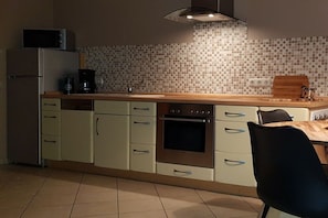 A kitchen with a microwave, coffee maker, and a wooden countertop. - Holiday apartment with 2 bedrooms (Karlshagen)
