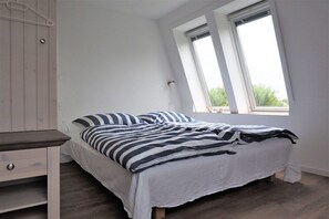 Ein Schlafzimmer mit einem Bett, einem Nachttisch und einem Fenster.
