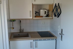 A kitchen with a sink, a coffee maker, and a knife block. - Apartment with 1 bedroom (Wenningstedt\/Sylt)